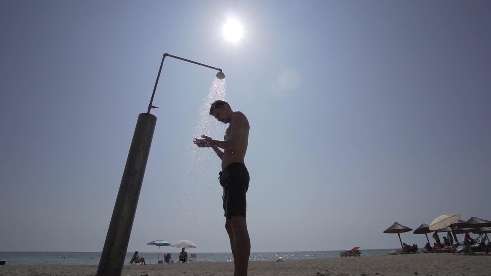 男人在沙滩上洗澡和太阳对抗电影拍摄镜头视频的预览图
