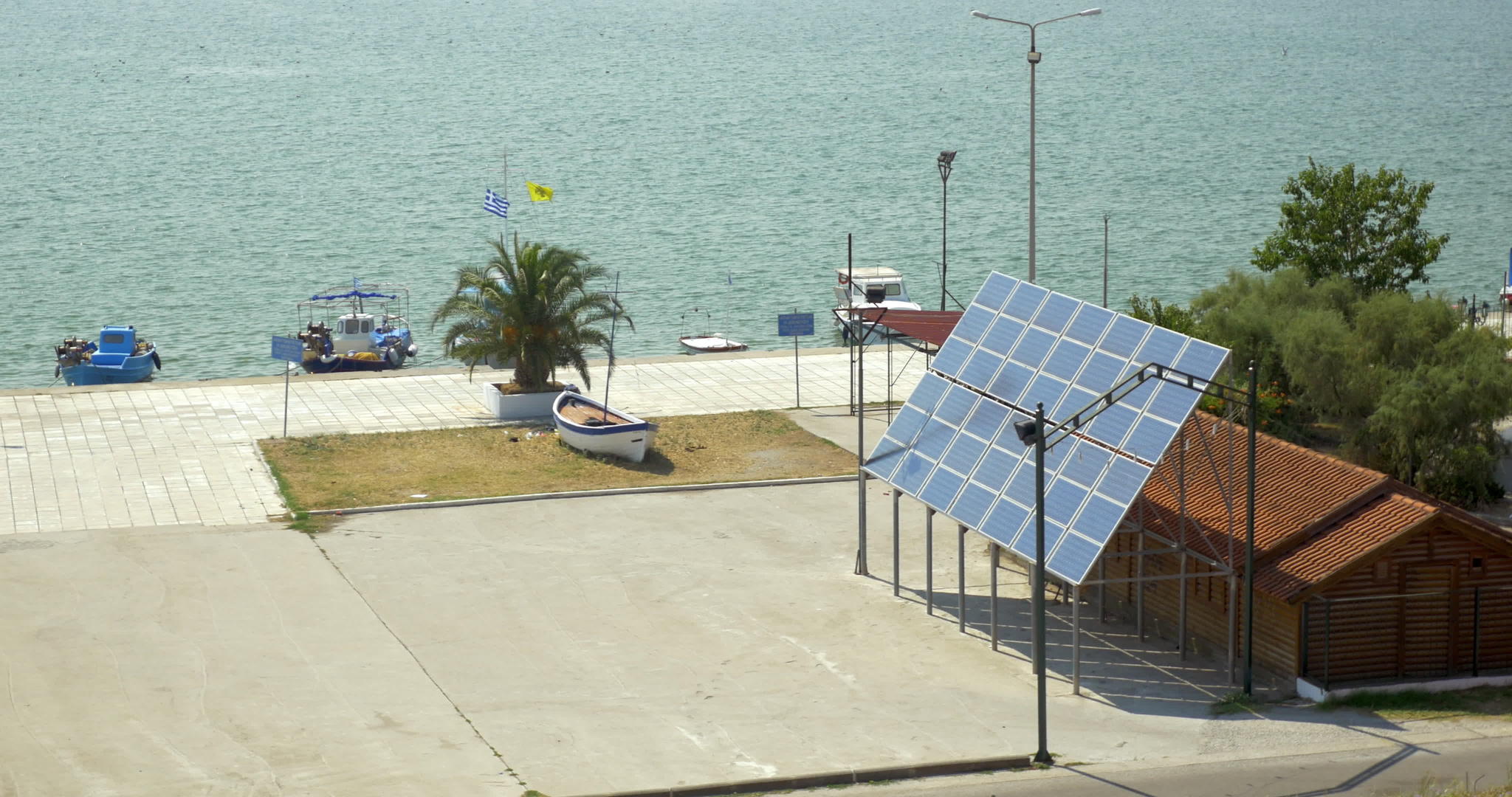 太阳能电池板固定在房子旁边背景是一片平静的海洋视频的预览图