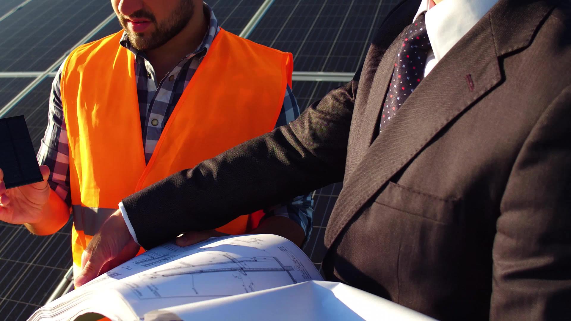 太阳能电池板背后是工人和商人对讨论项目的看法视频的预览图