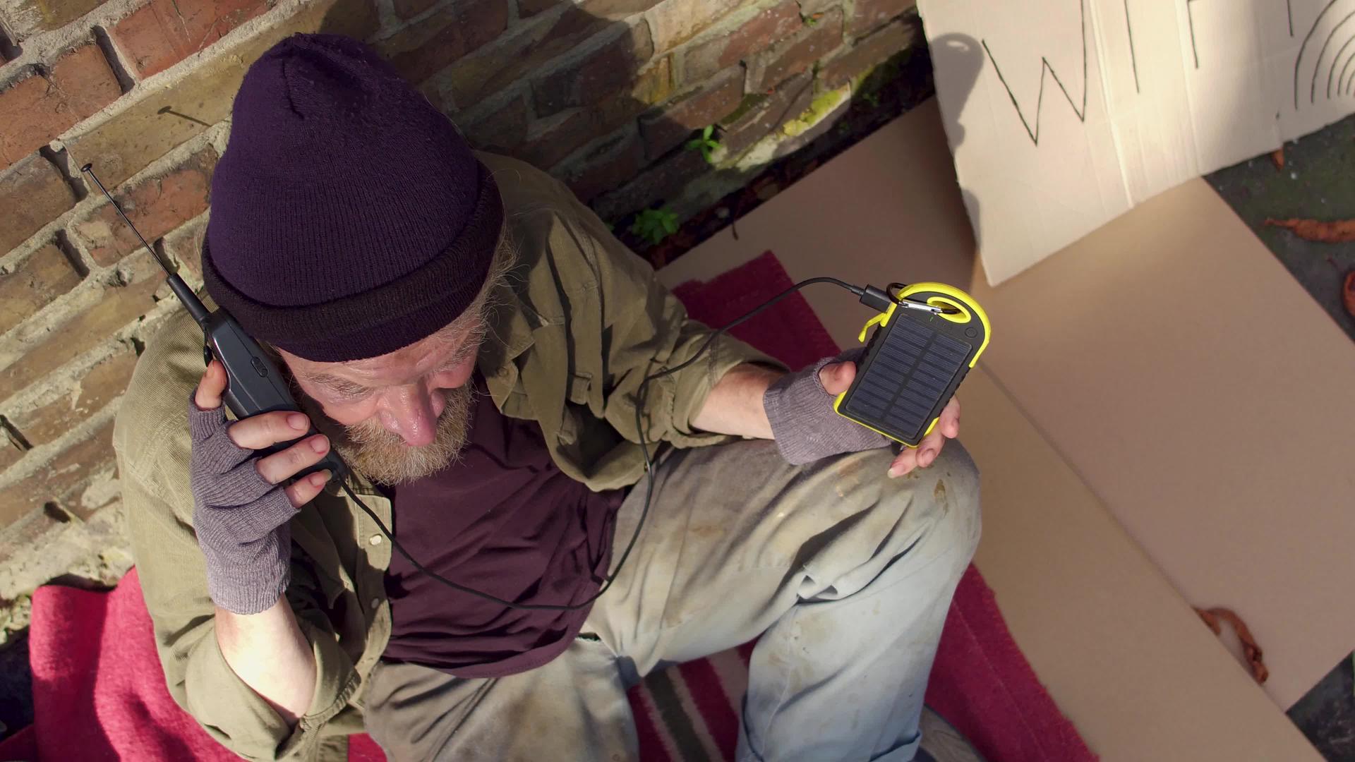 无家可归的人使用光电元件给手机充电他们用太阳能充电视频的预览图