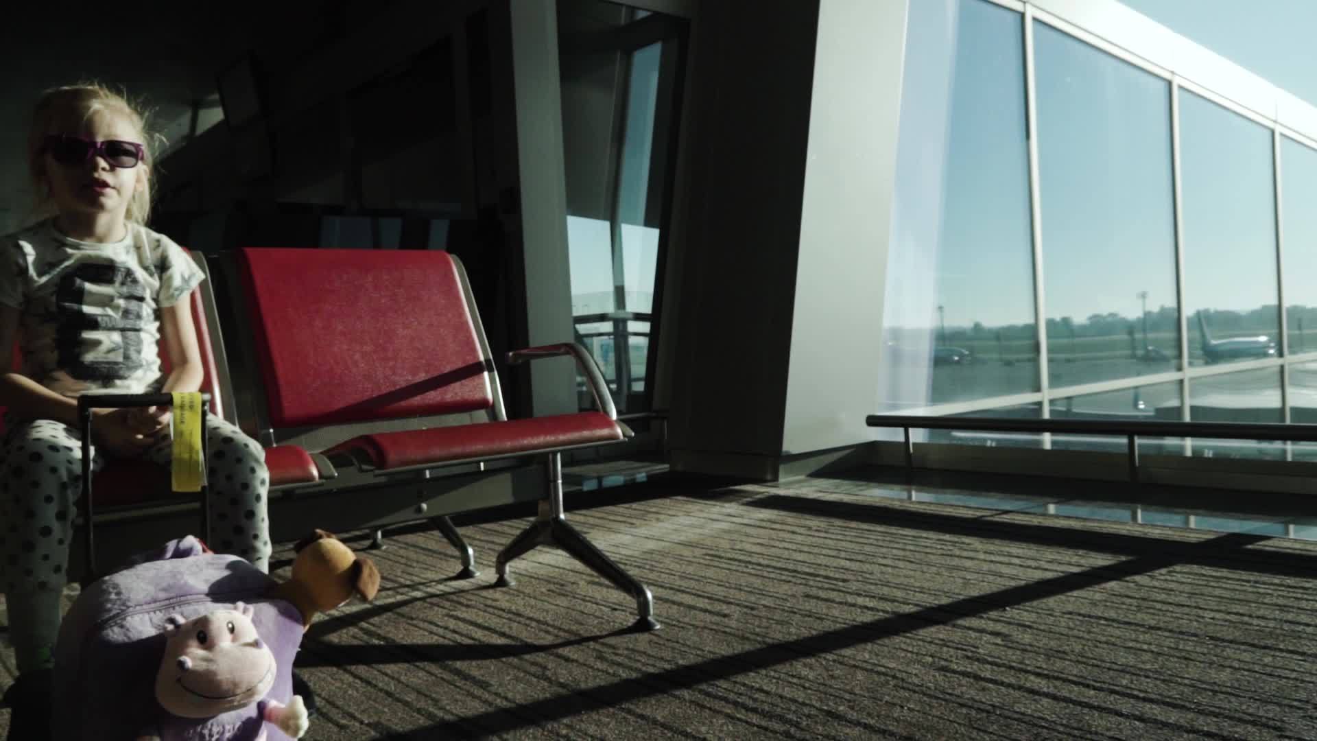小女孩戴着太阳镜在机场候机楼门口等着日出时戴着太阳镜视频的预览图
