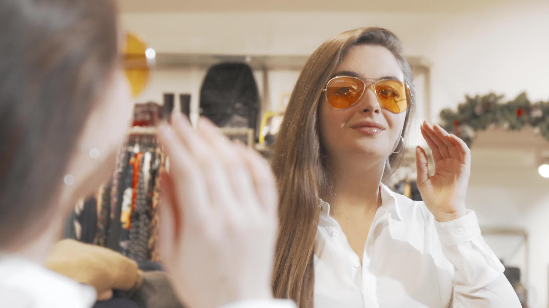 可爱的年轻美女在时装店试穿新墨镜视频的预览图