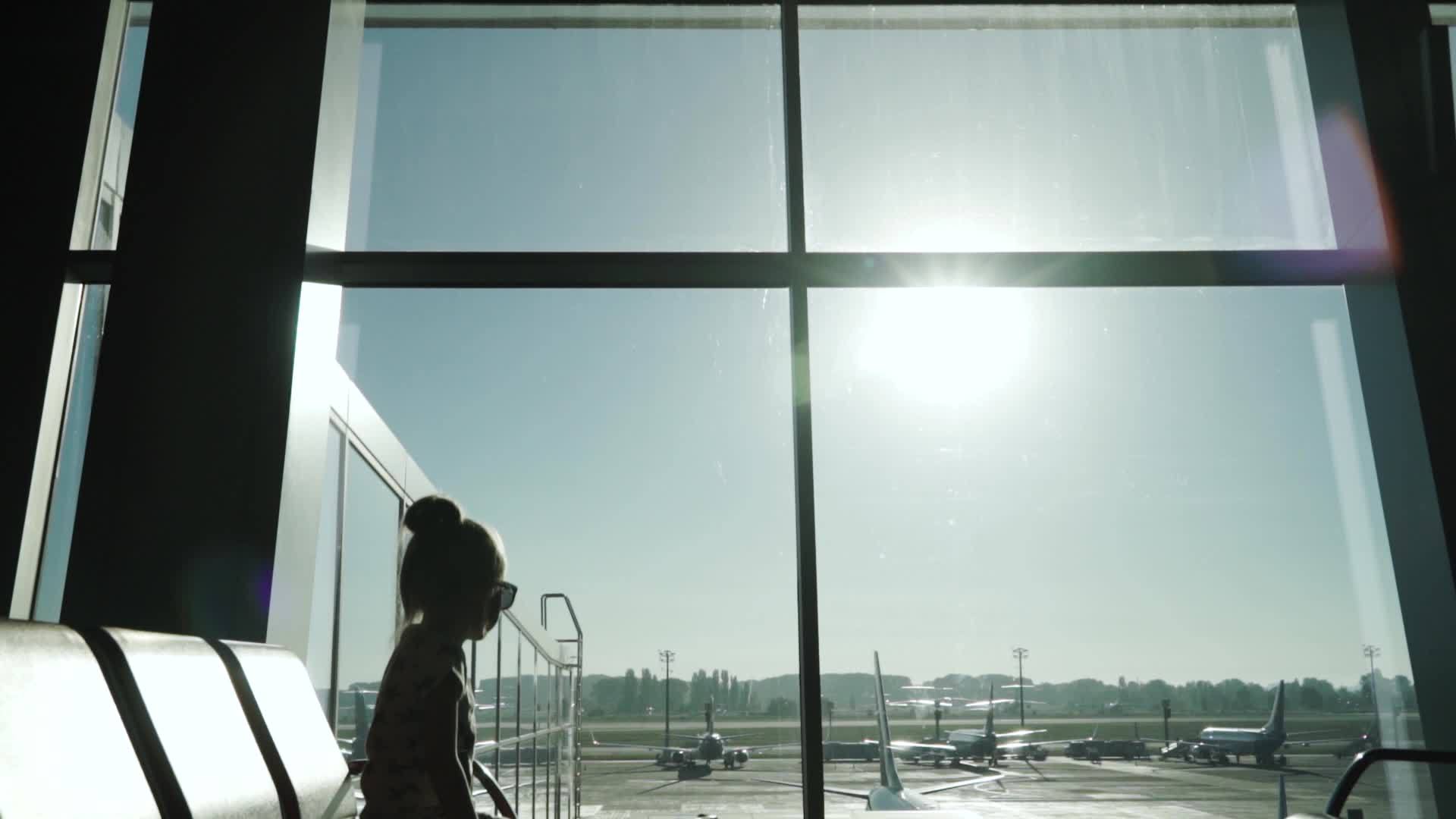 在机场客运终点站等待飞机的小女孩视频的预览图