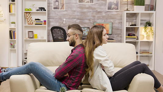 一对夫妇坐在沙发上双臂交叉坐在沙发上视频的预览图