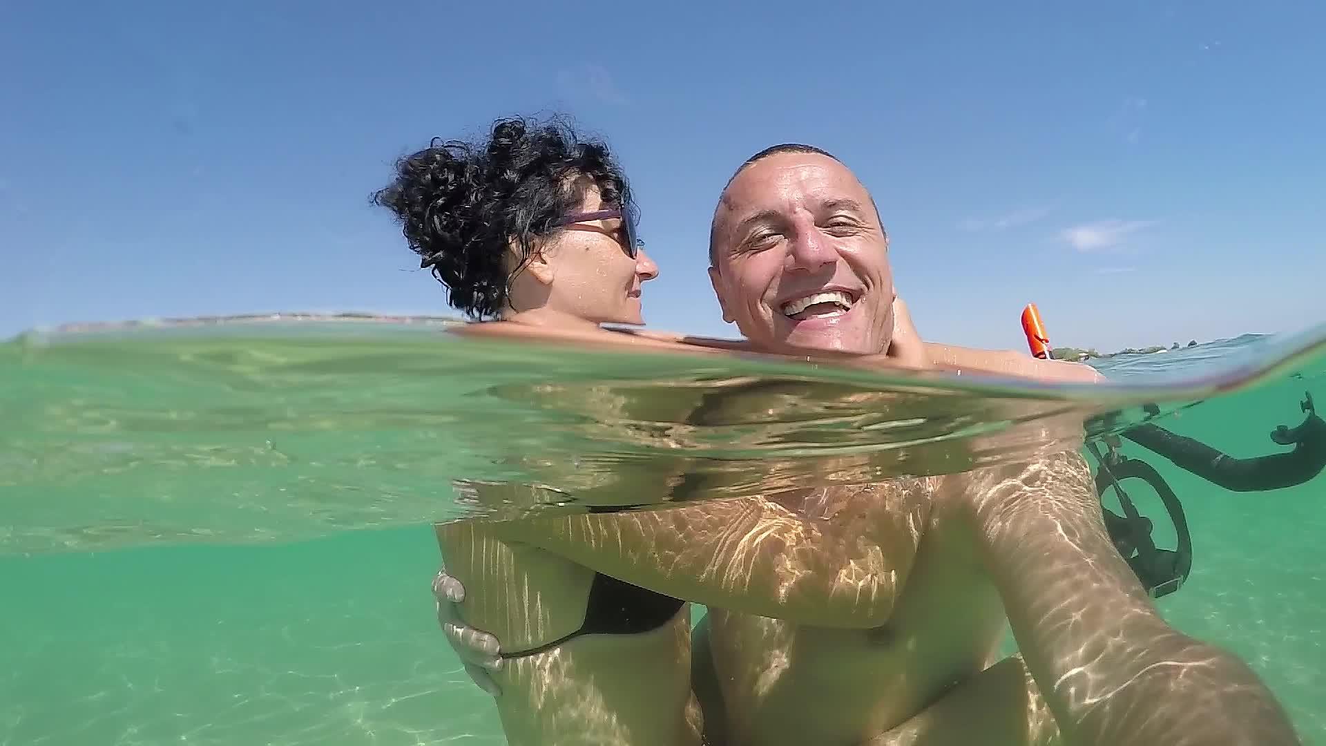 暑假里快乐浪漫的情侣们在沙滩上微笑着提神gopro视频的预览图