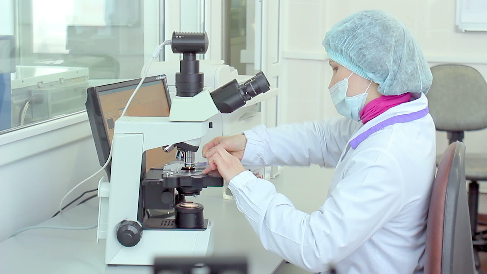 女研究员在实验室通过显微镜检查视频的预览图