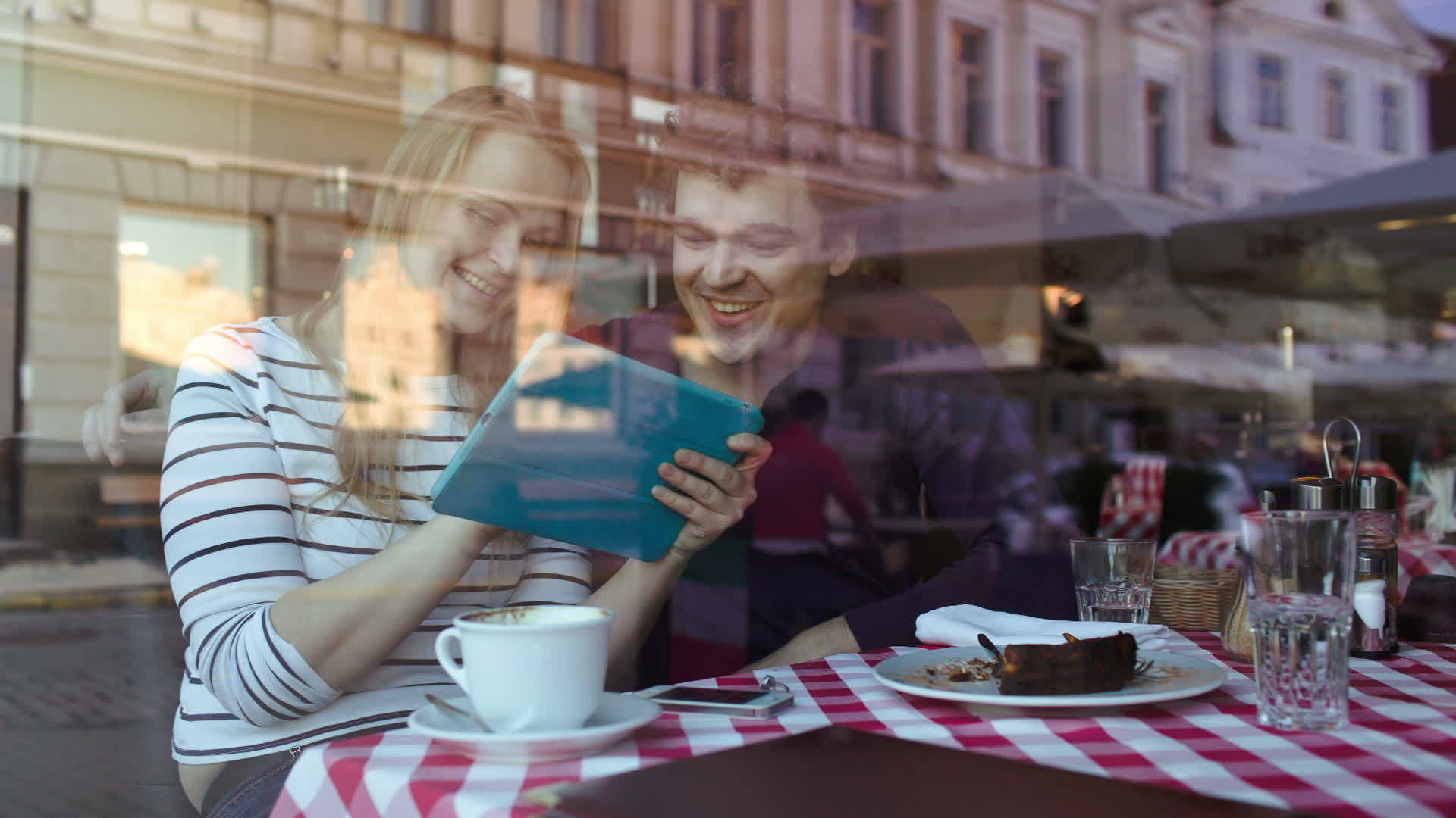 快乐的年轻夫妇在咖啡馆里有平板电脑视频的预览图