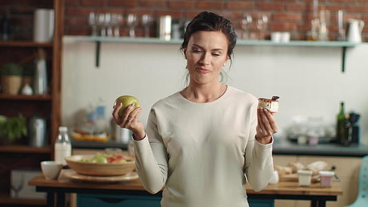 家庭生活减肥女性选择水果或蛋糕视频的预览图
