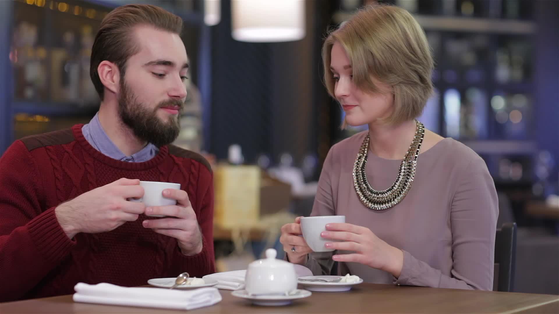 年轻美丽的情侣在美丽的咖啡馆里喝咖啡的爱情肖像视频的预览图