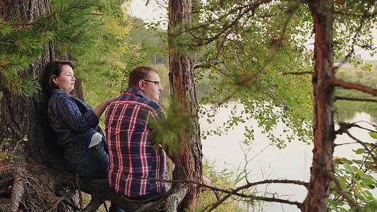 中年夫妇坐在河边放松后视线视频的预览图