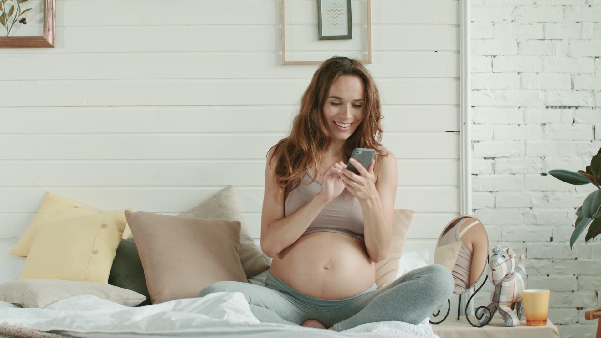 怀孕的妈妈在家休息看手机视频的预览图