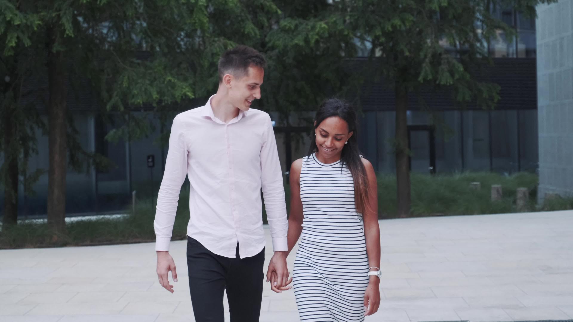 两个多种族的恋人走在街上互相拥抱互相交谈互相解释视频的预览图