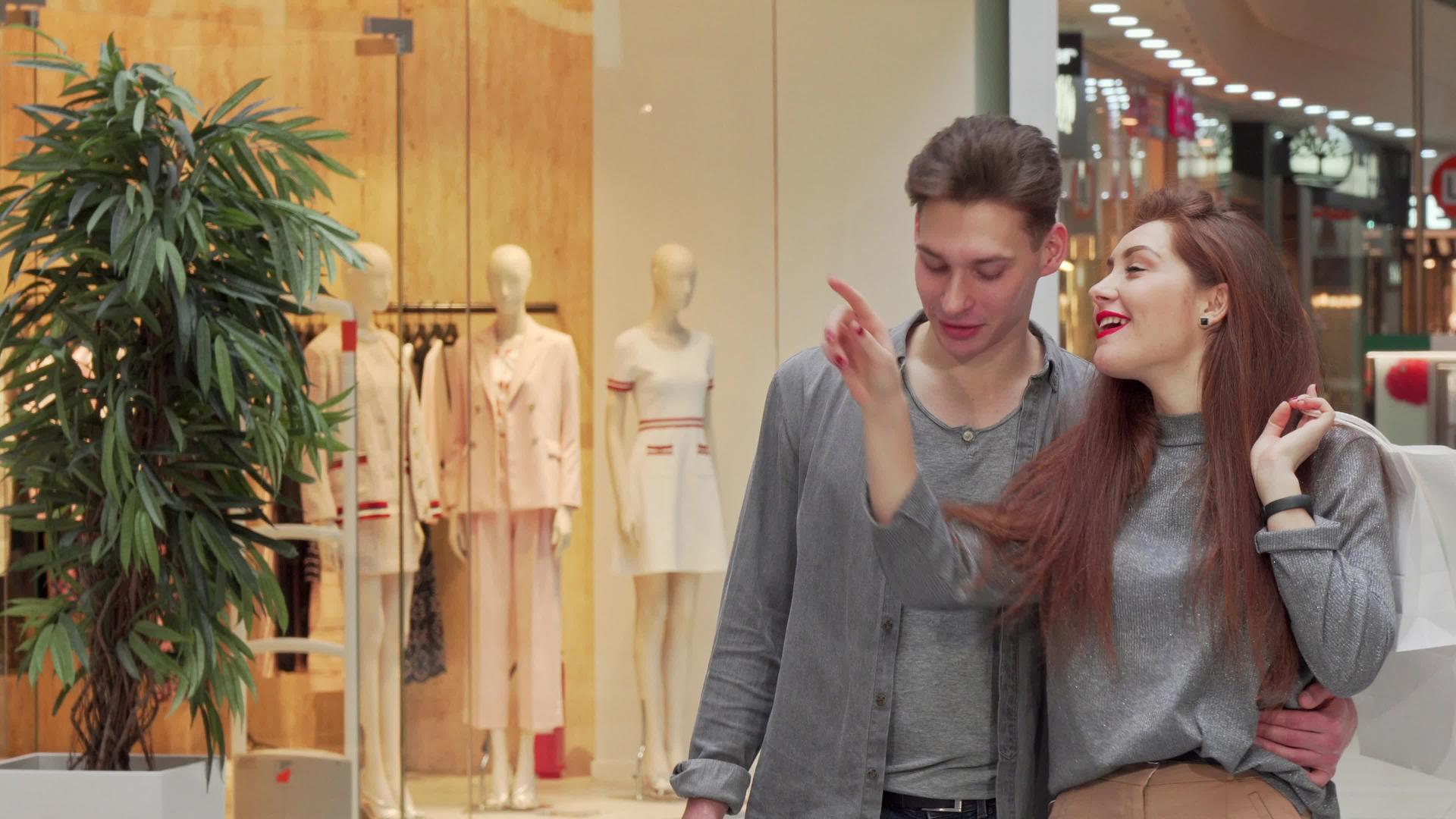 年轻夫妇在商场散步享受季节性销售视频的预览图