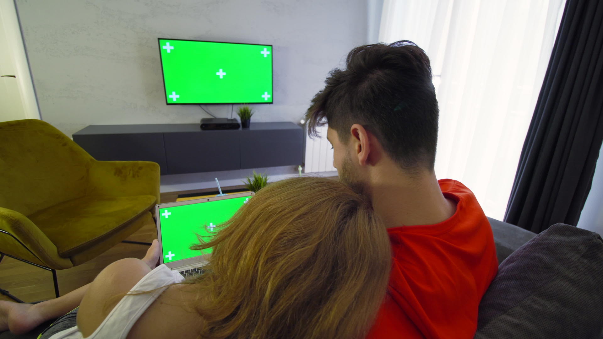 一对夫妇使用绿色屏幕笔记本电脑和电视视频的预览图