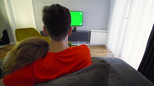 两对夫妇在客厅里抱着一个绿屏电视女孩视频的预览图
