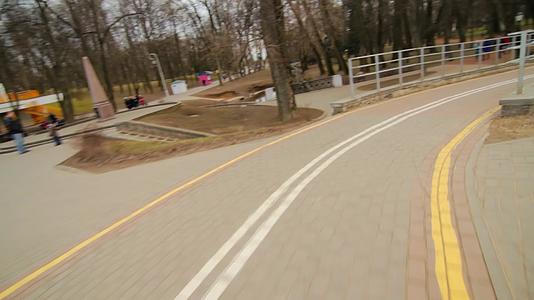 沿着城市公园的堤岸骑自行车视频的预览图
