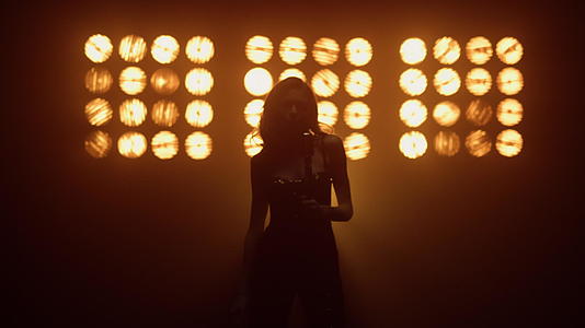 优雅的专业女歌手在灯光下唱歌视频的预览图