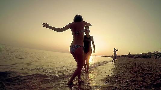 女孩和情侣在阳光明媚的日子在海滩上慢慢地跳舞视频的预览图