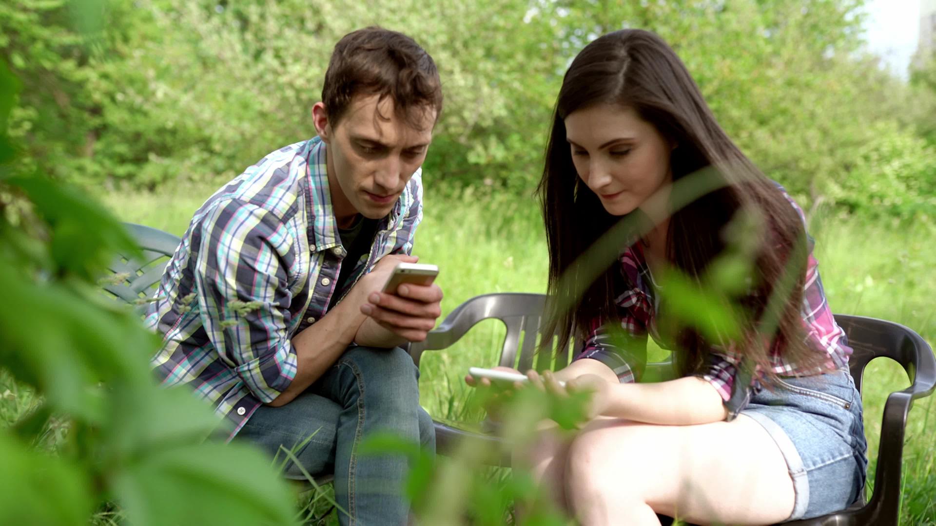 两个朋友坐在电话里照片显示在手机上视频的预览图