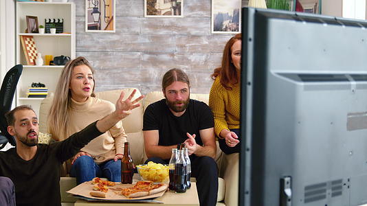 两对夫妇在电视上看足球比赛时欢呼起来视频的预览图
