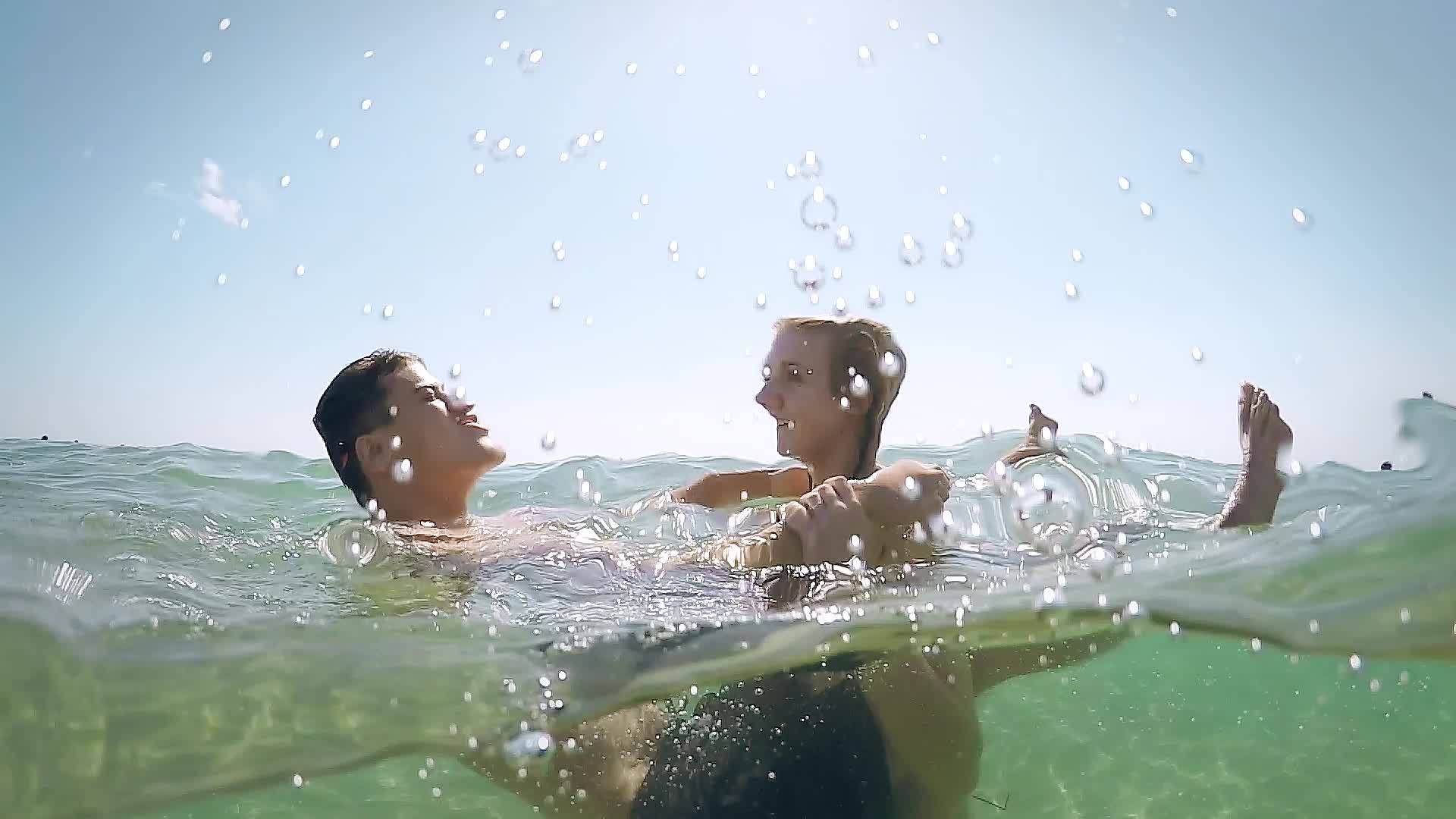 一对浪漫的夫妇拥抱并在海滩上慢慢地在水中亲吻gopro视频的预览图