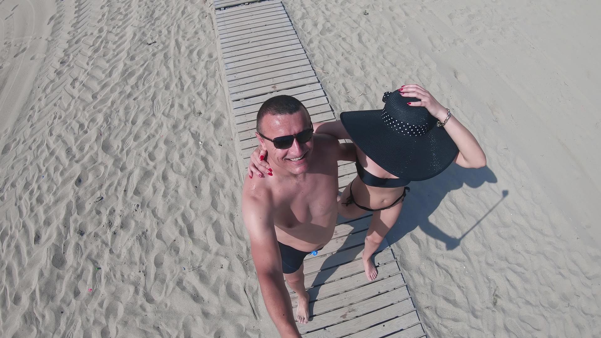 一对夫妇走在海滩木行道上视频的预览图