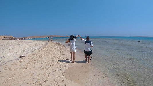 一对浪漫的夫妇在浅热带特色岛屿天堂海滩上huhadaegypt视频的预览图