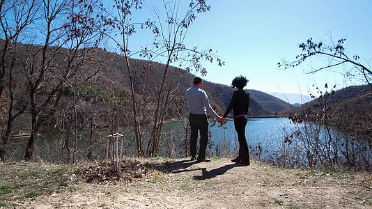 在山湖边情侣们手牵手亲吻拥抱着一对浪漫的情侣视频的预览图