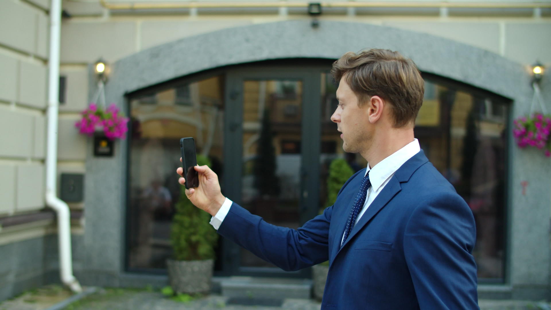 街上的商人举起手机视频聊天视频的预览图