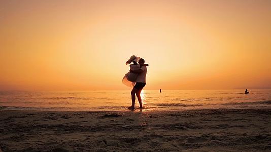 快乐的恋人日落时在海边视频的预览图