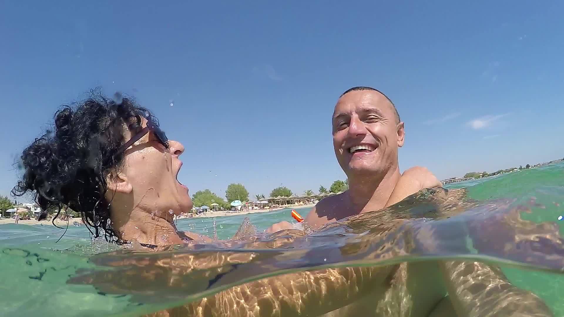 暑假期间年轻夫妇在海里拥抱泼水Gopro圆顶半视频的预览图