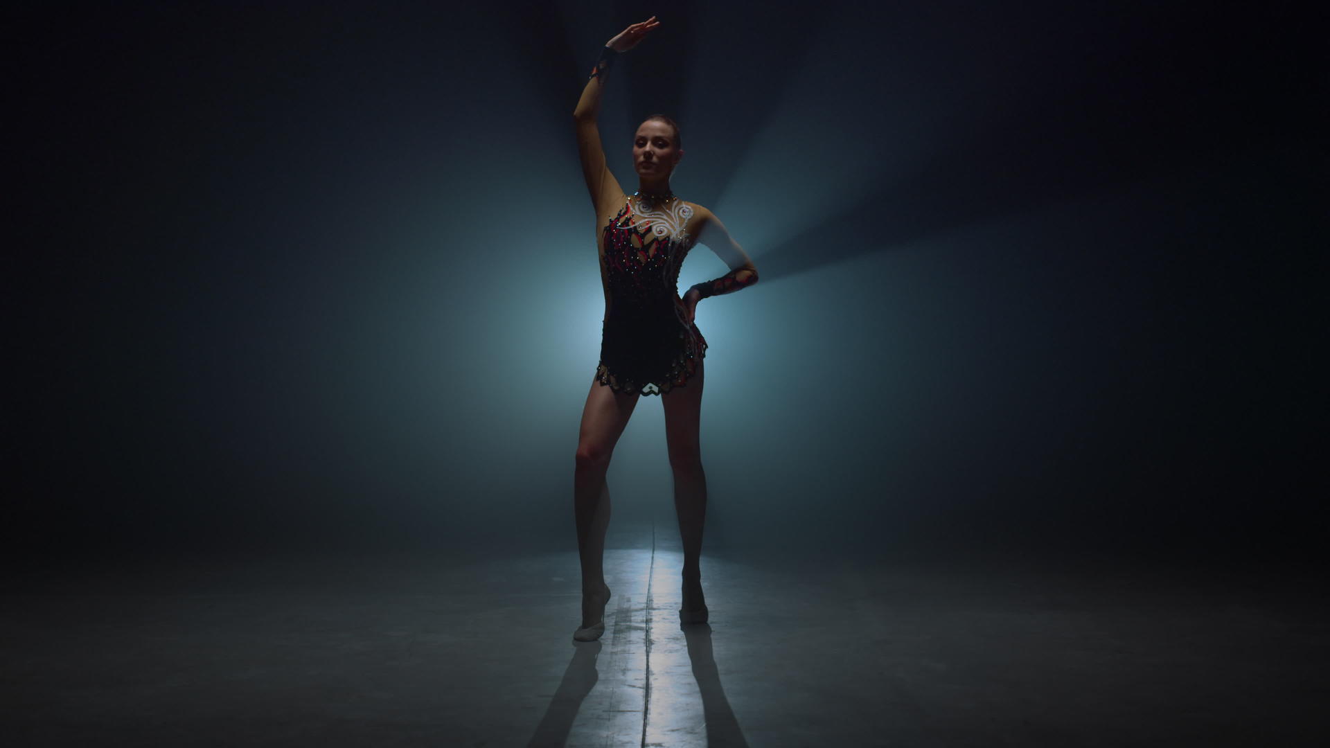艺术体操女孩站在黑暗的空间里表演技巧视频的预览图