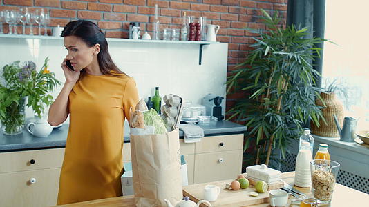 住在家里的女人打电话把新鲜蔬菜放在厨房里视频的预览图