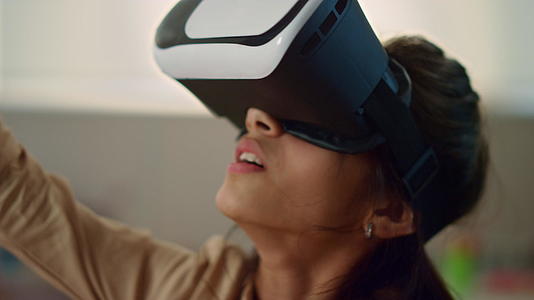 沉浸在虚拟现实中的女孩戴着虚拟现实耳机视频的预览图