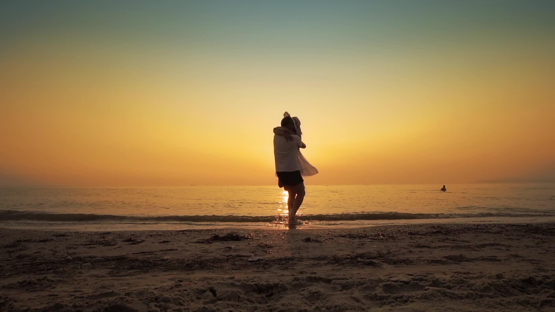 日落时一对幸福的夫妇在海边翻转视频的预览图