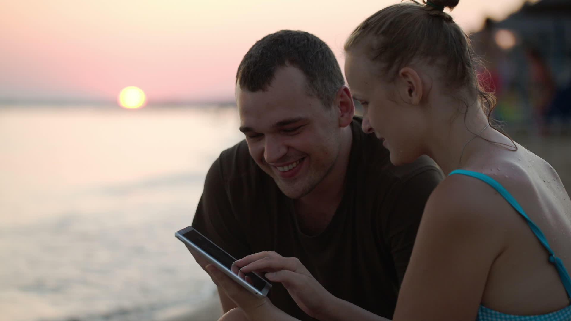 男人和女人在海滩上有平板电脑视频的预览图