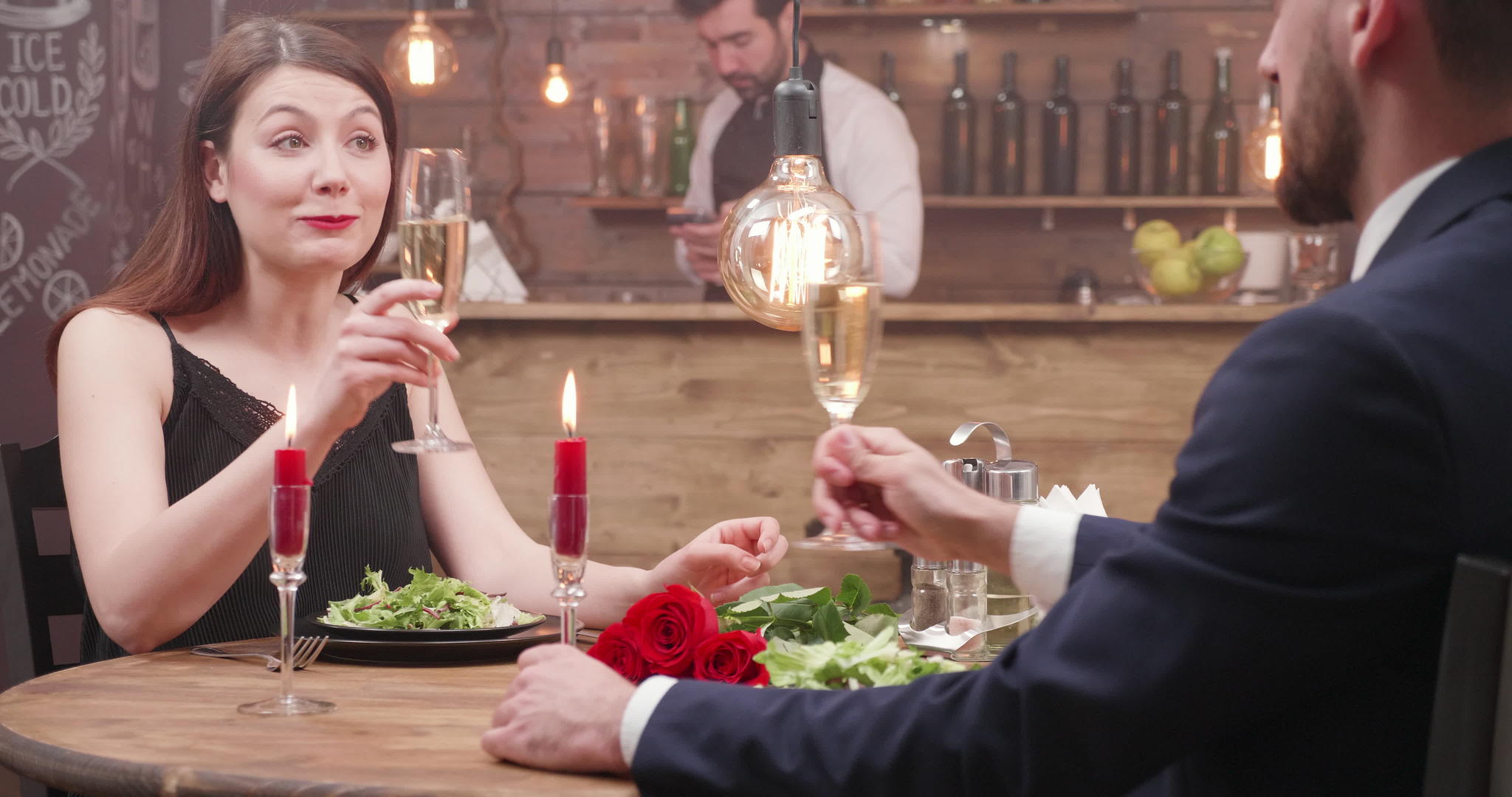 相爱的情侣坐在餐厅的餐桌旁喝香槟视频的预览图