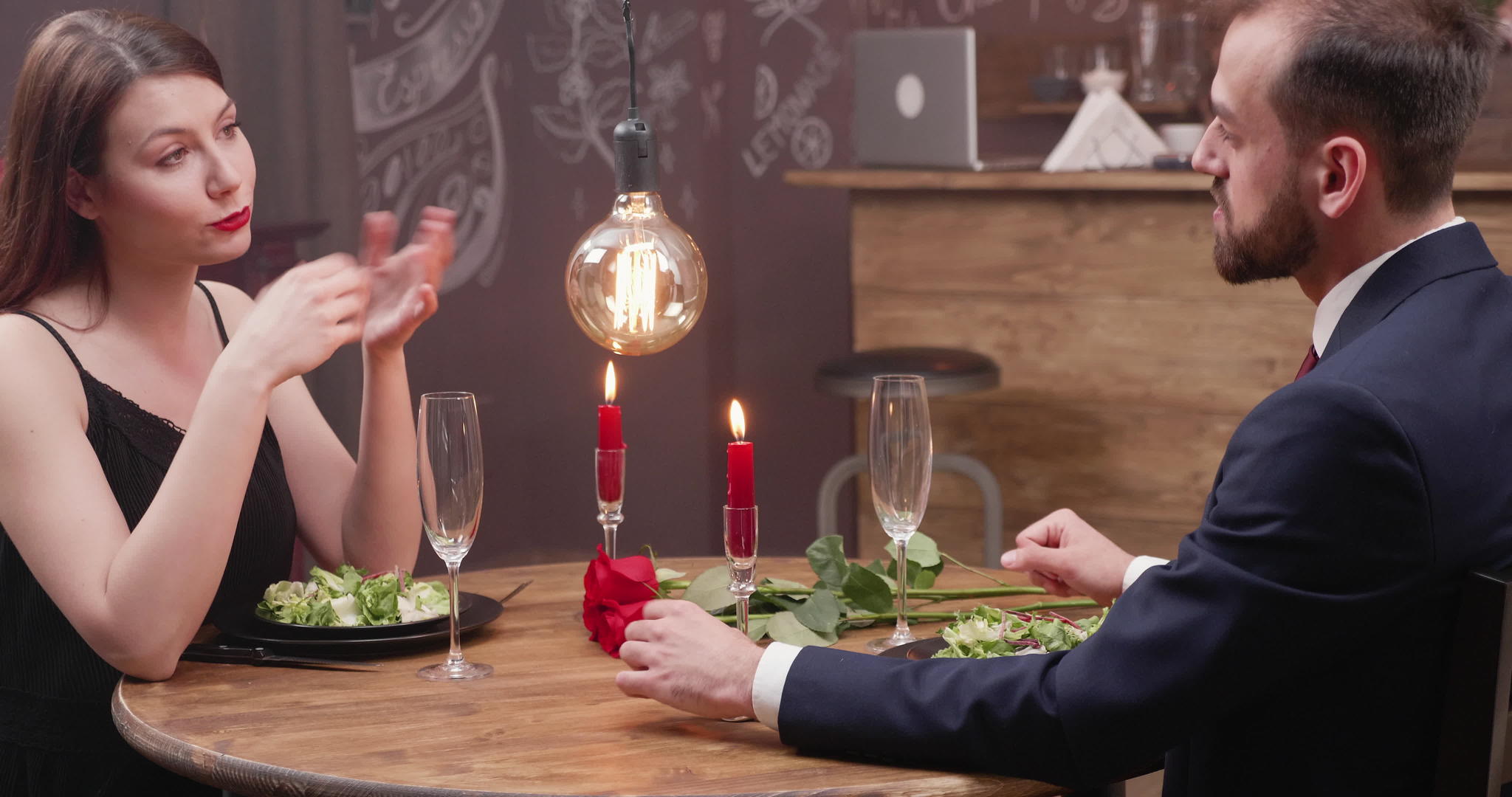 在浪漫的晚餐中美丽的年轻女士与男人交流视频的预览图