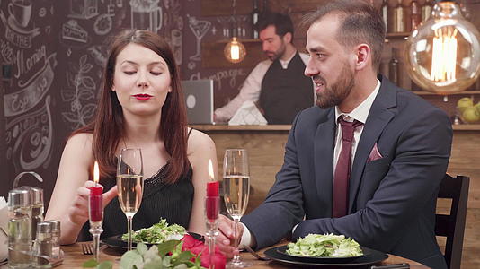 年轻夫妇在晚宴上喝了一杯闪亮的红酒视频的预览图