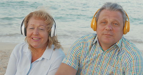 老夫妇在海滩上享受音乐视频的预览图