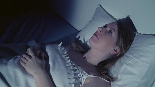 一个失眠的女人躺在床上眼睛躺在床上视频的预览图