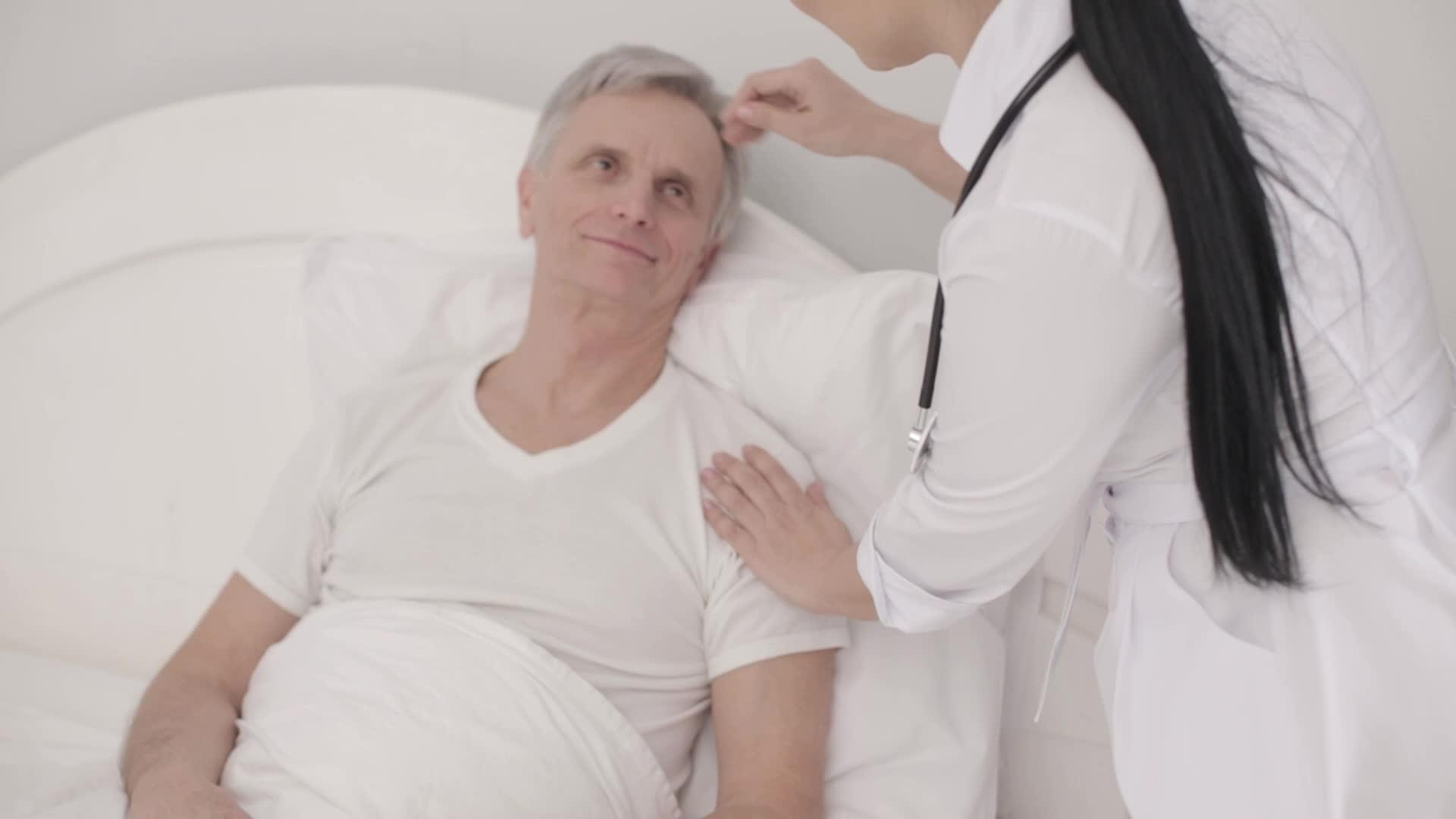 在床上照顾残疾老人的迷人医生视频的预览图