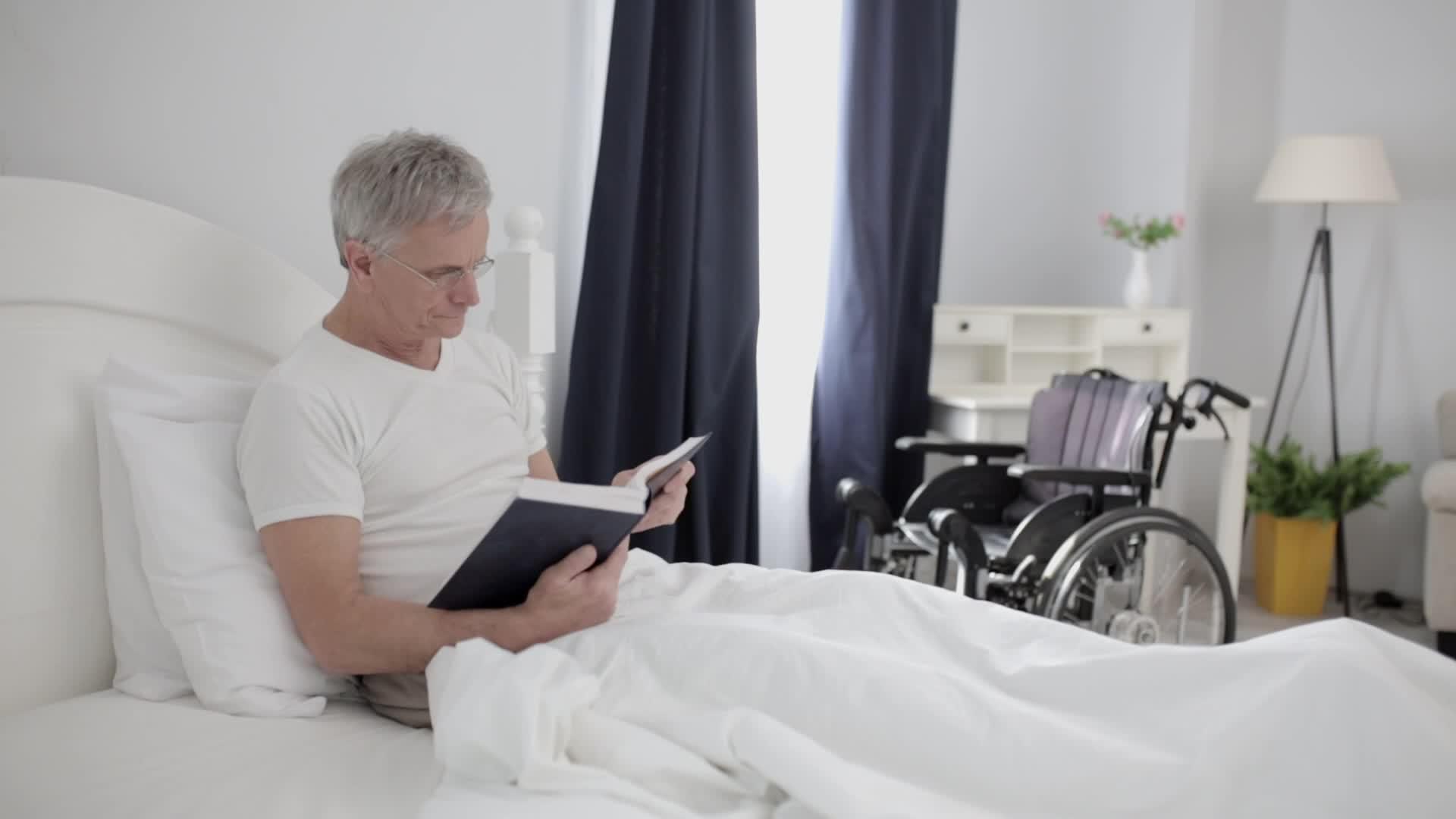 一个在医院里有灰发的成年男子躺在他身上Vip房间的床上视频的预览图
