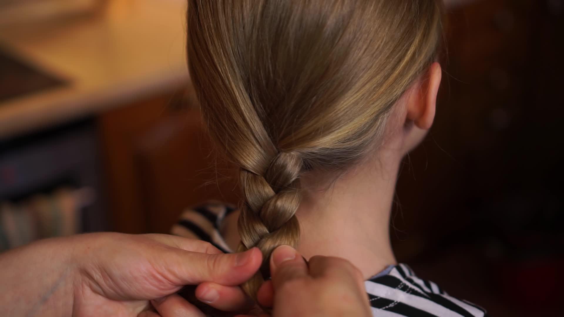 慈爱的母亲帮助女儿编织发型视频的预览图
