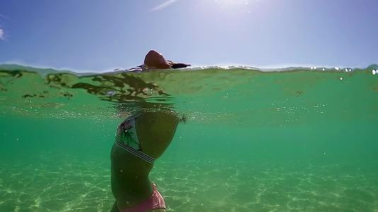 年轻女孩的湿毛肖像在海绿水中暑假期间瓜半水下观景慢动作视频的预览图