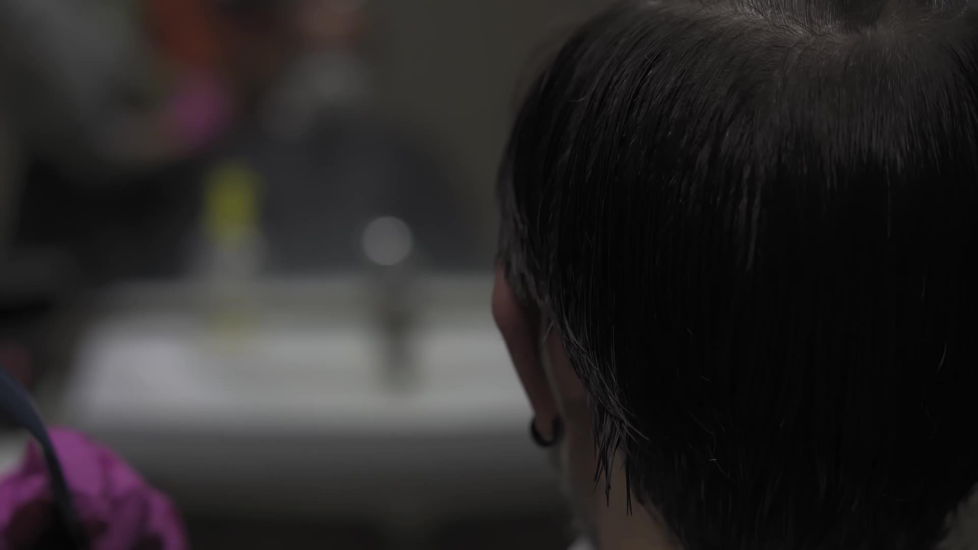 用理发师的手和剪刀将头发长度与背景镜的光线对齐视频的预览图