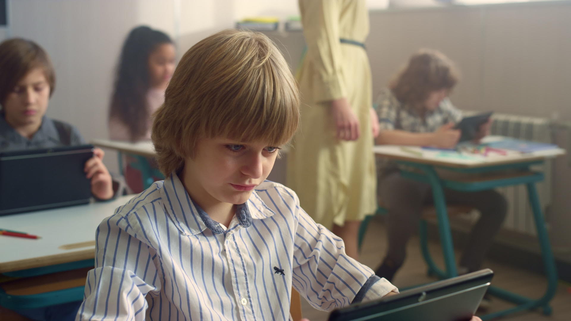 在课堂上男孩看着数字平板电脑的屏幕视频的预览图