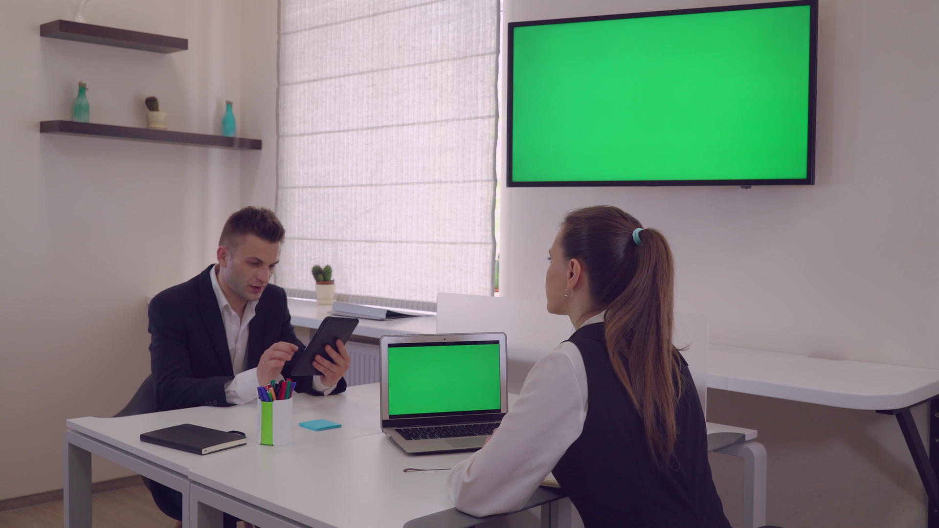 两个商业伙伴坐在现代办公桌前视频的预览图