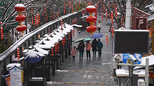 慢镜头升格拍摄4k素材冬天飘雪的节日氛围红灯笼街道路人雪景4k素材视频的预览图