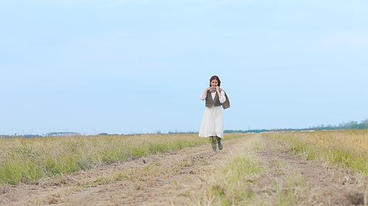 美女走在田野的小路上视频的预览图